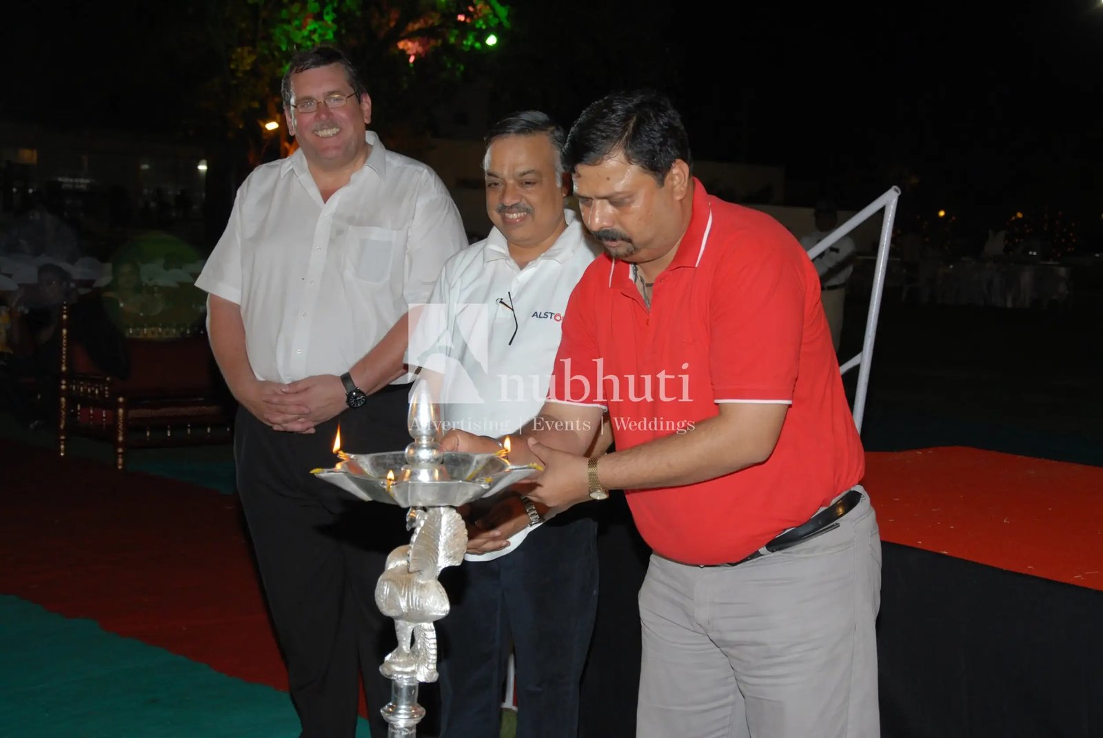 Musical performance on stage with three performers and ITT banner in background
